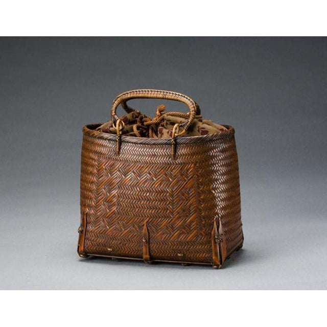 This small elegant woven bamboo basket was meant to be a hand-hold bag with its brocade interior (which appears original)....