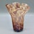 A hand-blown handkerchief vase in a tortoiseshell pattern that shifts with the light — creamy opaque glass mottled in...