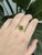 Set in solid gold and accented with sparkling diamonds, this stunning ring features a vivid 2.93ct oval-cut Peridot...