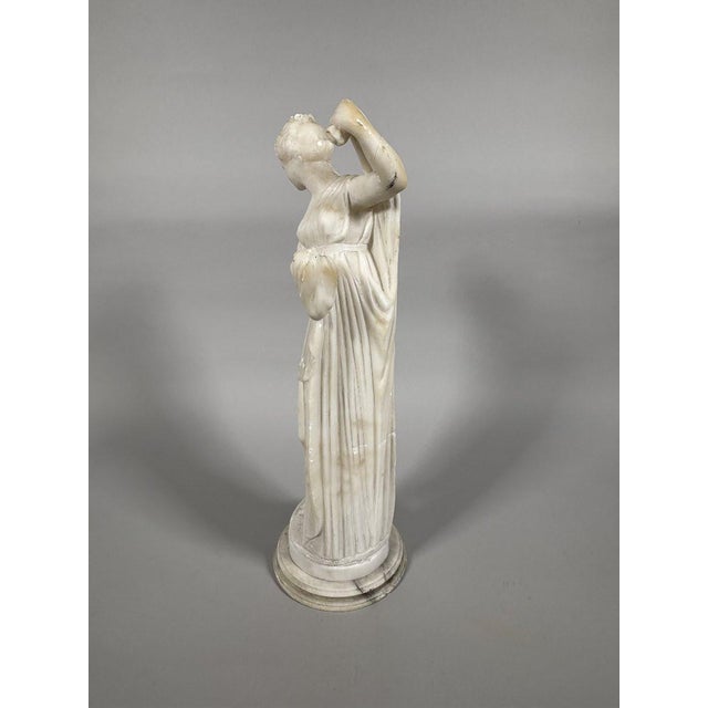 19th-century alabaster sculpture depicting a woman in the style of ancient Greece draping herself after her bath. French...