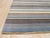 A 5' 6" x 8' hand-knotted wool rug with narrow stripes of slate blue, mocha, ivory and silver. Newly made in India. Size:...