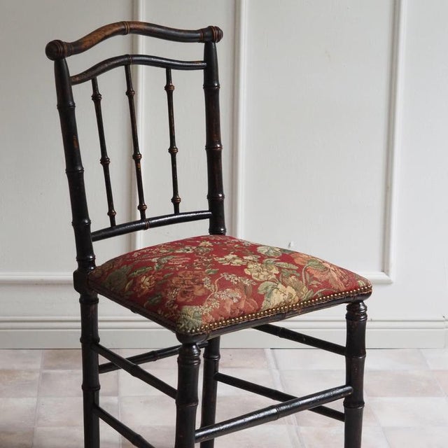 A bamboo-effect chair from around 1880, crafted in the style of the French Napoleon III, with a black-painted frame and...