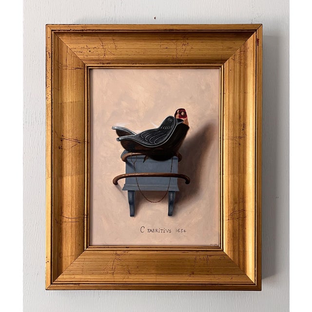 This artwork features a meticulously rendered silver finch perched atop a distinctive blue pedestal, creating a striking...