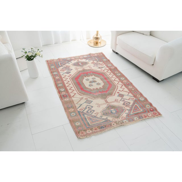 This is a vintage Turkish Oushak rug from the Mid 20th Century. The piece was hand-knotted.