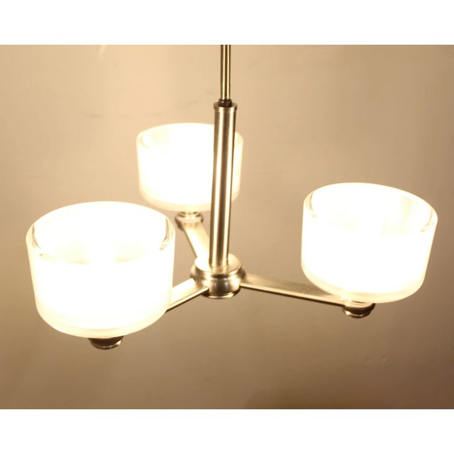 This 3-Light Brushed Nickel Chandelier features round frosted glass globes for a modern look. The adjustable post...