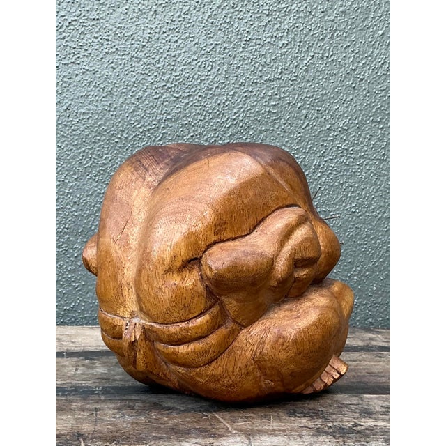 This evocative hand-carved wood sculpture presents a compelling interpretation of the traditional "crouching yogi" or...