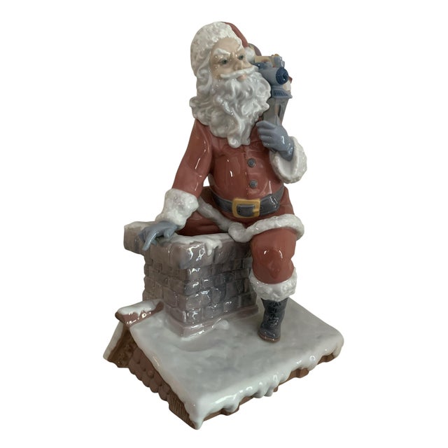 A Lladro classic from 2007, "Down the Chimney". A whimsical portrayal of Santa with his full pack of toys about to head...