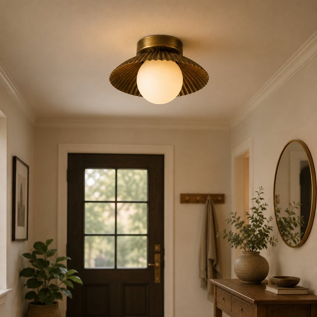 Crafted from solid brass and paired with a softly illuminated opal glass globe, this handcrafted flush mount ceiling light...