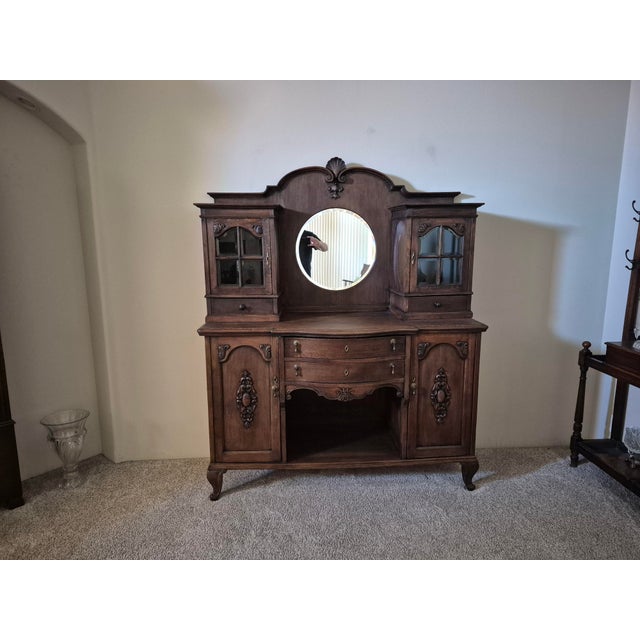 This is a unique and striking late 19th century buffet is in exceptional condition with a beveled mirror, four beautifully...