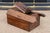 A rustic antique oak ballot box with heavily weathered patina, a shaped, scalloped-edge hinged lid, ballot slot and...