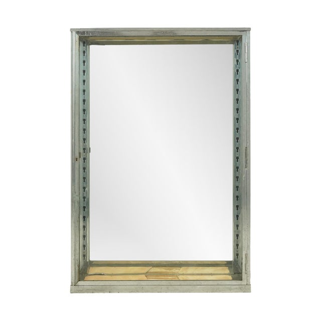 Vintage European countertop vitrine with a clear glass door, chrome finished brass frame, mirrored back, and slots to hang...