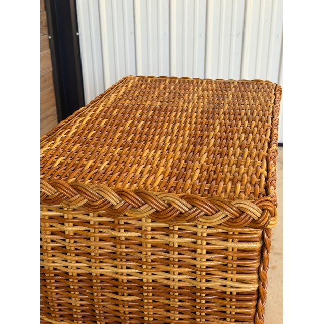 A beautifully crafted vintage three-drawer chest completely wrapped in woven rattan with substantial braided rattan trim...