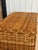 A beautifully crafted vintage three-drawer chest completely wrapped in woven rattan with substantial braided rattan trim...