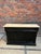 This old bar counter has been completely restored. It consists of a black patinated cabinet and a raw wood top. At the...