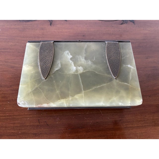 An antique and unusual jewelry box in the style of a book. The lid is made of green onyx; the back, spine, and bindings...