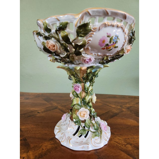 Stunning pedestal porcelain fruit bowl from Germany, featuring reticulation, gold trim, as well as raised flowers and...