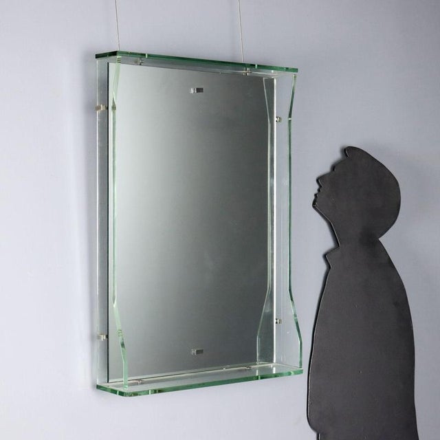 Mirror with open shelf and glass surround. Clear and mirrored glass. This piece is attributed to the mentioned...