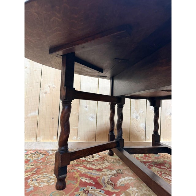 A gateleg drop-leaf table in solid oak, stamped Thos Turner, Manchester, an English manufacturer active in the late 19th...