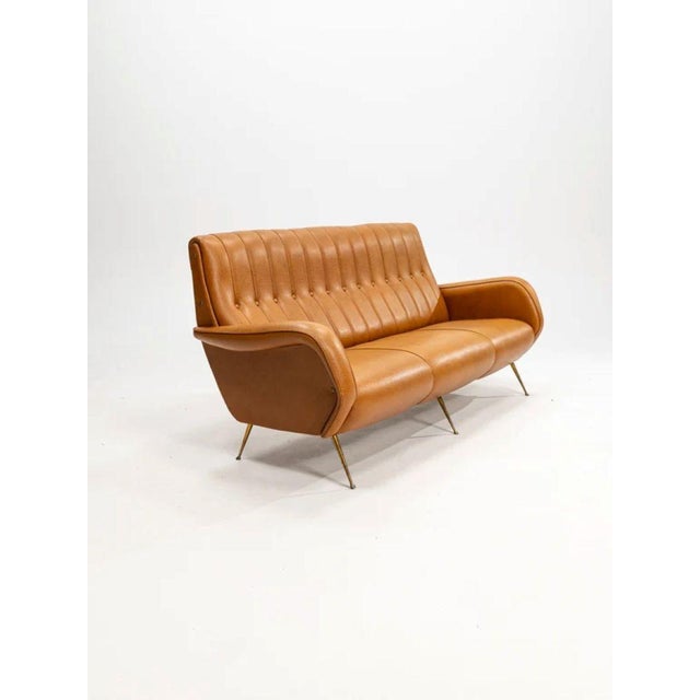 This sofa is a vintage mid-century modern three-seater couch, often associated with italian design from the 1950s or...