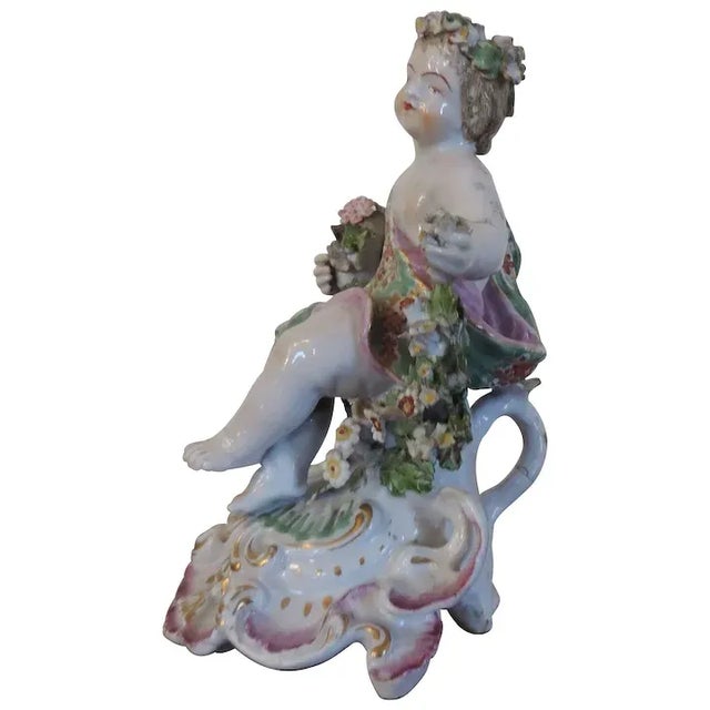 Antique 18th c. English Derby porcelain cherub figure dating from 1765. Figure rests atop a floral garland of bocage in...
