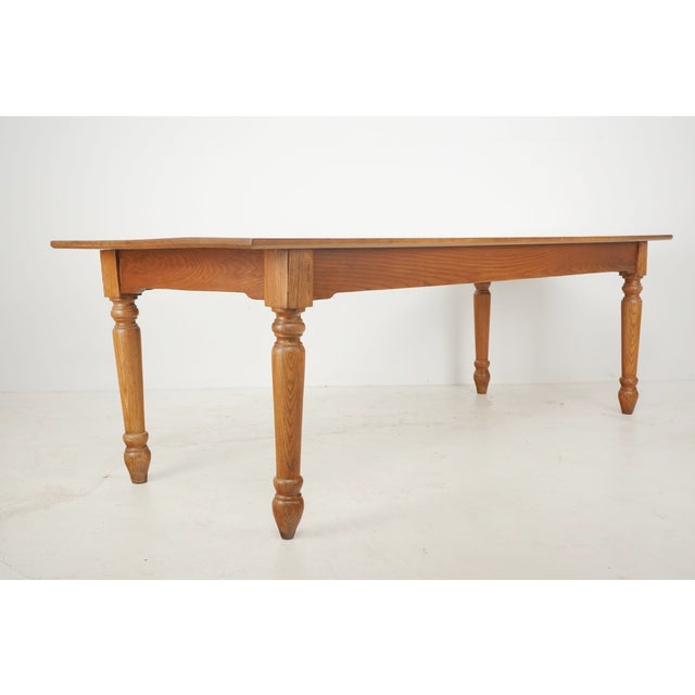 Reclaimed Farmhouse style dining room table made of medium stained oak. The table features thick, elegant baluster turned...