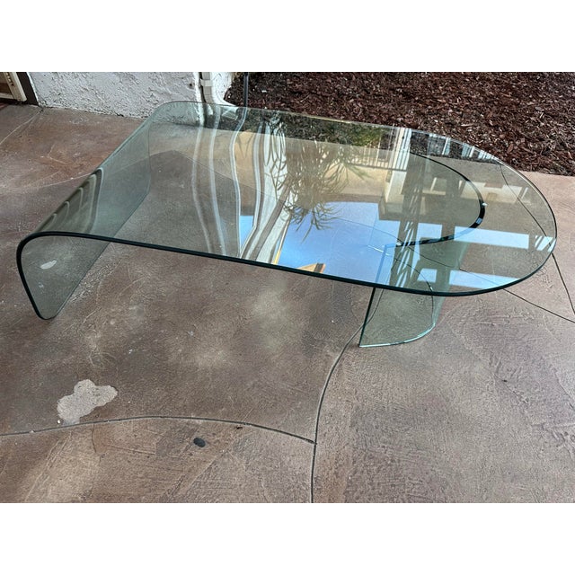Beautiful waterfall style curved glass coffee table, vintage Post Modern and believed to be from Italy. Two separate...
