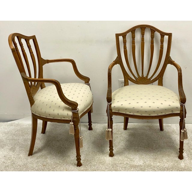 This is a pair of carved fruitwood Adam style shieldback chairs by Baker Furniture. They are marked and in very good...