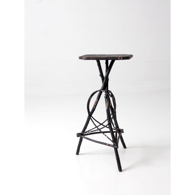 Antique Adirondack twig table with a hand-built branch base and octagonal plank top. A sculptural composition of bent twig...