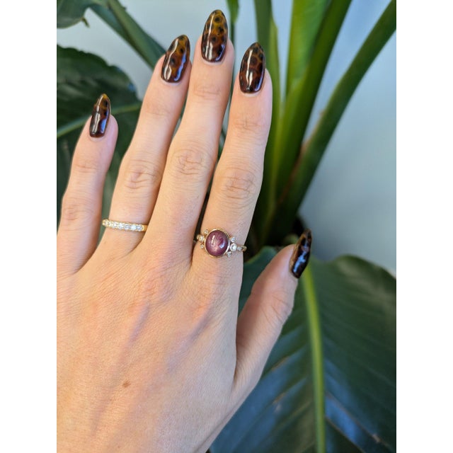 A 4.62-carat star ruby displays a soft six-rayed star across its domed cabochon, set in solid 14K rose gold with eight...