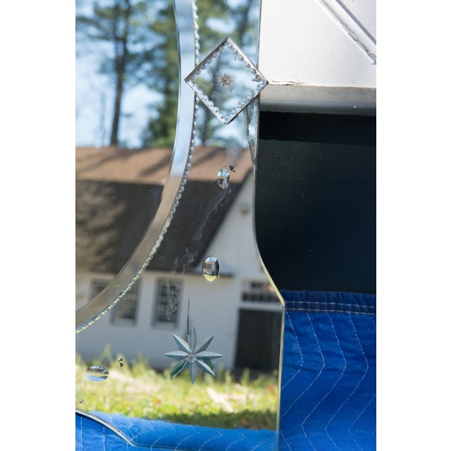 Purchased in Paris, a 1940s mirror framed mirror with etched and carved decorations with a solid wood back. Eight pointed...