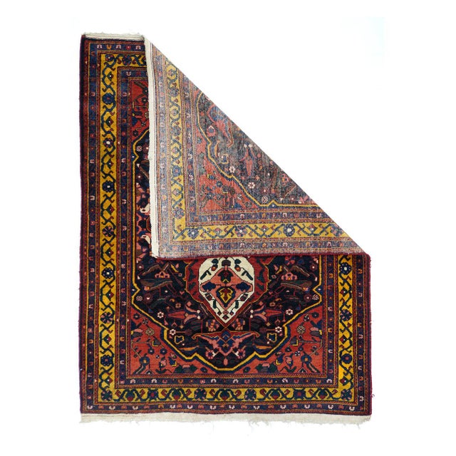 The particularly bold ecru medallion features four internal palmettes and four pointed finials. The red ground is centred...