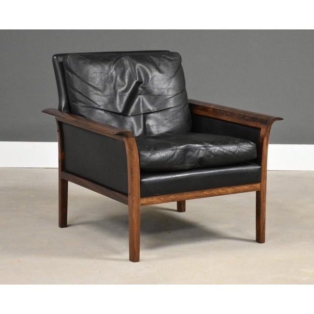 A mid century modern black leather lounge chair with rosewood arms designed by Knut Saeter for Vatne Möbler. Beautiful...
