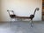 Striking vintage rustic bench featuring an elegant wrought iron frame with dramatic scrolled arms and decorative ironwork...