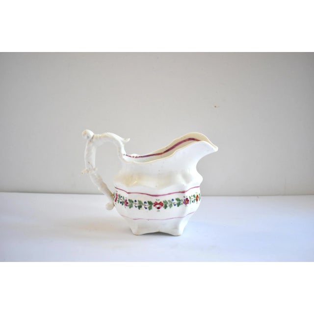 An antique Georgian, c. 1810-1820 small pitcher, gravy boat, or sauce boat. With painted flowers around the middle and...