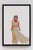 In "Watcher," a figure in a flowing beige dress captures attention with an intense gaze, creating an atmosphere of...