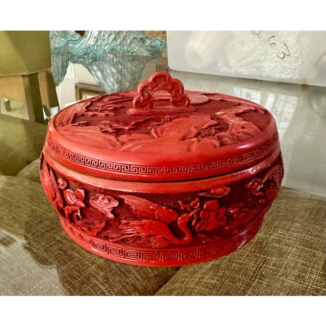 Well crafted antique Chinese cinnabar lidded box with blue enamel interior. Intricately carved throughout with cranes,...