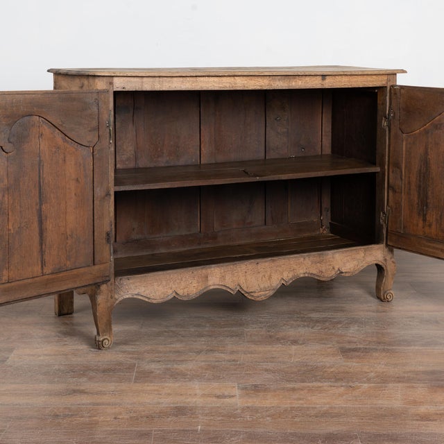 19th century French sideboard crafted in oak and finished with a bleached surface that highlights the natural grain of the...