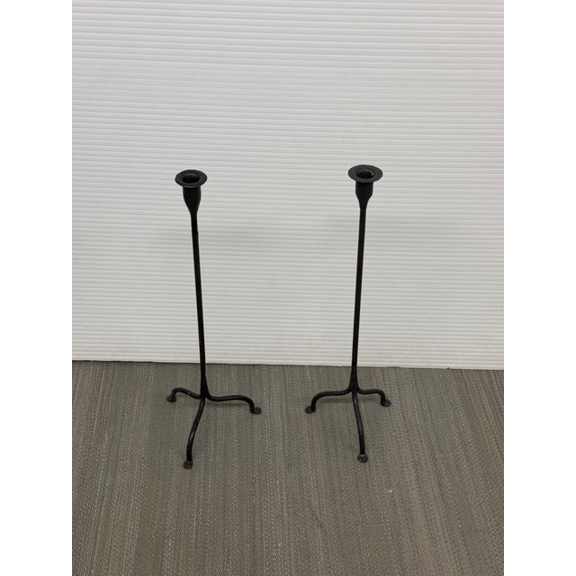 Design Plus Gallery presents a Pair of Black Iron Tripod Candlesticks. Each candlestick is formed in iron with a slender...