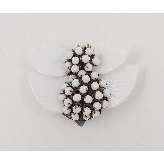 This is part of Chairish’s Costume Jewelry assortment. 1930s silvertone white glass leaves and white glass beads dress...