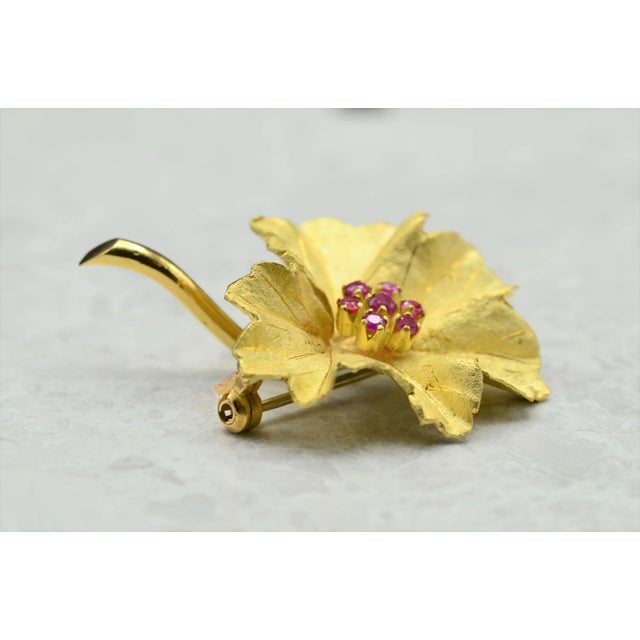 The Lyra Vintage Signed 18 Karat Yellow Gold Floral Brooch set with Rubies. This exquisite brooch is handmade with both...
