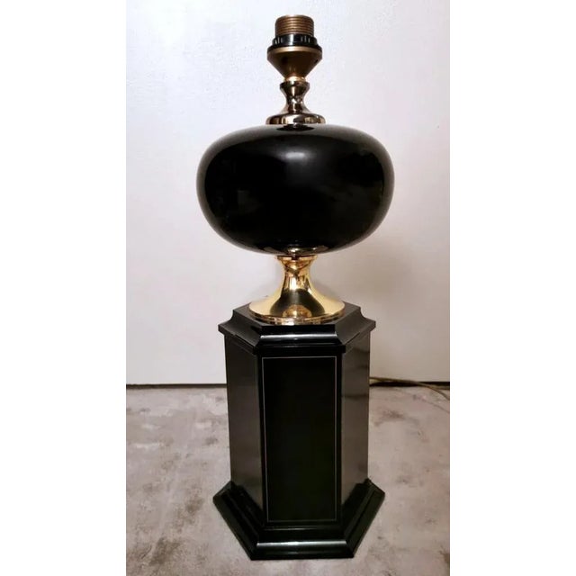 Iconic and refined french table lamp; the elegant, hexagonal-section base is made of black lacquered wood and grows in...