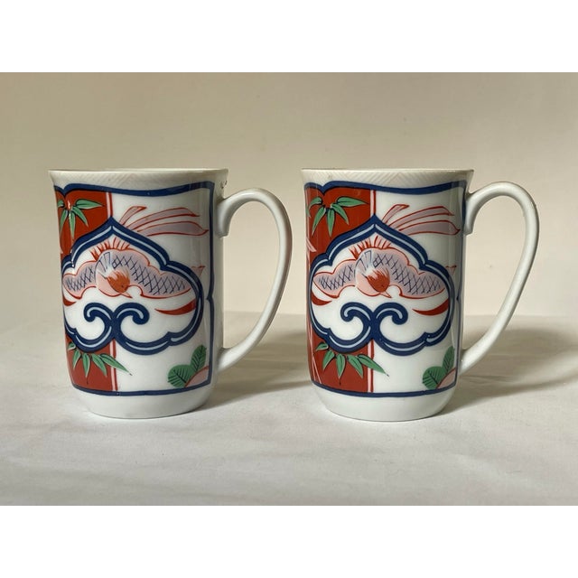 A pair of mid century chinoiserie mugs by Georges Briard. The design features bamboo and cherry blossoms with a a bird...
