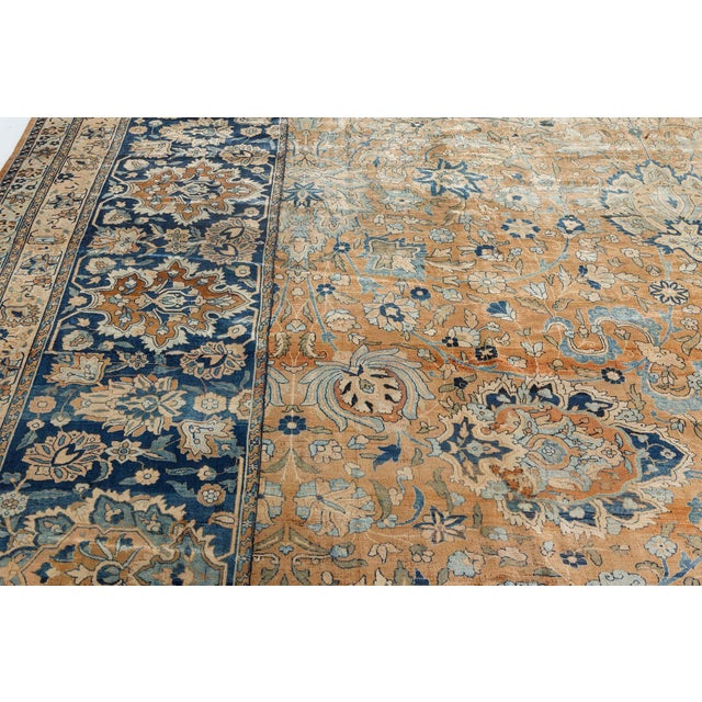 An early 20th century Persian Kirman rug, the rust field with an enlarged palmette, whimsical leafy vine and cloud band...