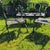 Cast aluminum, black painted surface. Two-seat settee and pair of armchairs with seahorse and seashell motif backrests....