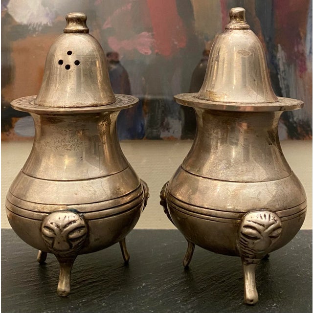 Striking pair of plated brass salt and pepper shakers. We love the feet and unique bulbous form. Original "Made in India"...