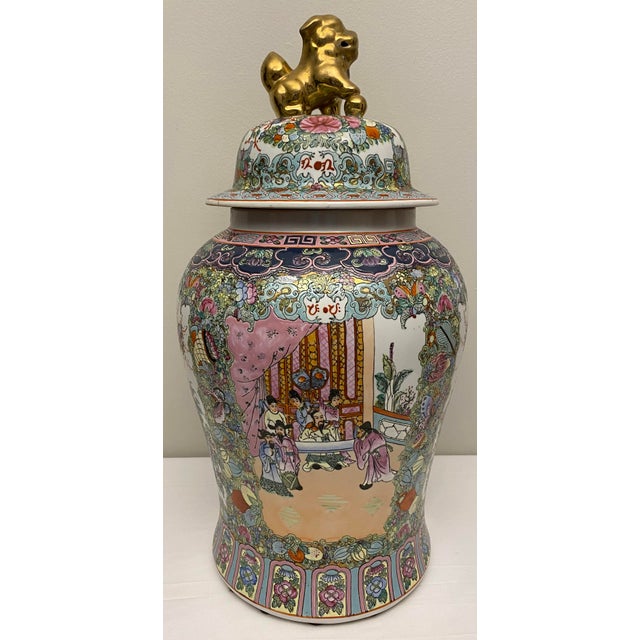 A beautiful, hand-painted Chinese famille rose temple jar decorated with foliage design and floral panels, gold lion dog...