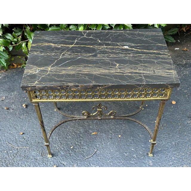 Lovely french dark grey marble top table with gilt iron/bronze pierced apron surrounding the marble. Turned legs with...
