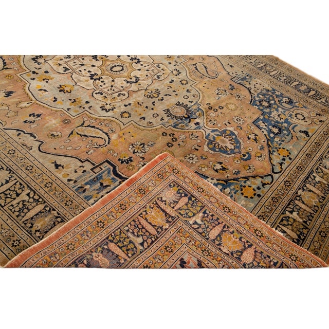 Beautiful antique Persian Tabriz hand-knotted wool rug with a light blue and peach field. This piece has a navy-blue frame...