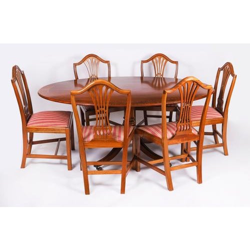 This is a beautiful Regency Revival flame mahogany and satin wood banded oval dining table made by the Master Cabinet...