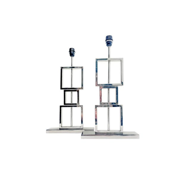 Striking pair of modern table lamps featuring a sculptural composition of stacked open square frames in polished chrome....